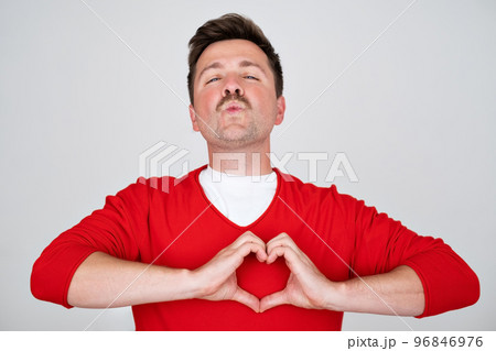 Young handsome man in love doing heart symbol shape with hands.  96846976