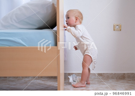 Caucasian baby girl playing hide and seek with her parents.  96846991