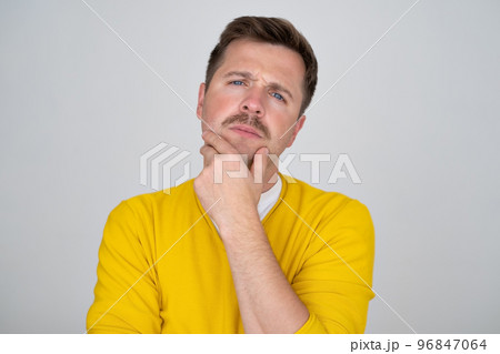 Thoughtful caucasian young man touch chin with finger thinking Thoughtful caucasian young man touch chin with finger thinking 96847064