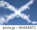 きれいな青空に浮かぶ「×」の形をしたふわふわな雲 96848871