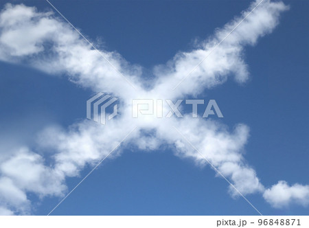 きれいな青空に浮かぶ「×」の形をしたふわふわな雲 96848871