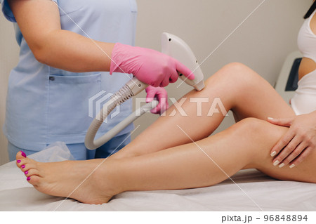 A close-up of the work of a cosmetologist who performs a laser hair removal procedure in the office 96848894
