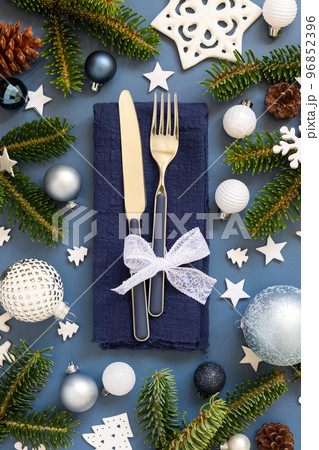 Blue and white Christmas table setting with decorations and fir tree branches top view Blue and white Christmas table setting with decorations and fir tree branches top view 96852396