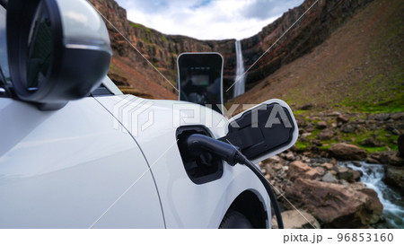 Progressive concept of energy sustainability by EV car in the waterfall. 96853160