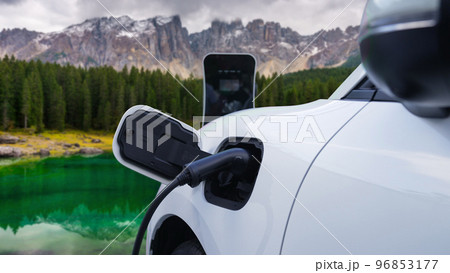Progressive travel concept by EV car in remote mountain with charging station. 96853177