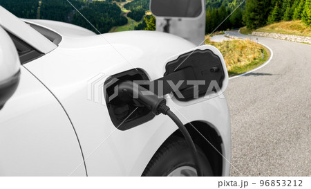 Progressive concept by electric car at the charging station on the hill road. Progressive concept by electric car at the charging station on the hill road. 96853212