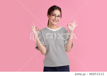 Portrait happy Asian woman shows ok sign and looking at the camera on Pink background. Portrait happy Asian woman shows ok sign and looking at the camera on Pink background. 96853222