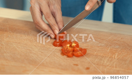 Close up hands holding a knife preparing a contented meal. 96854057