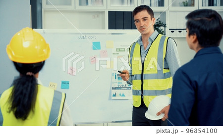 A team of investor and competent engineers brainstorming on the whiteboard. 96854100