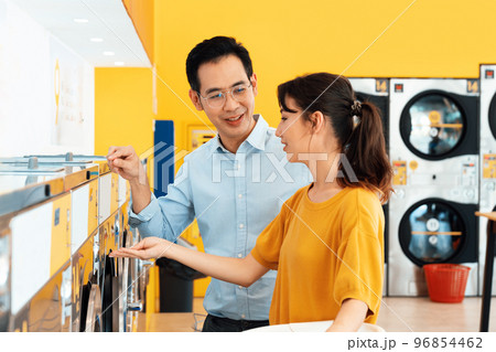 Asian people using qualified laundry machine in the public room. Asian people using qualified laundry machine in the public room. 96854462