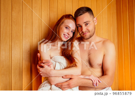 redhaired ginger woman and her boyfriend steaming in the bathhouse with russian bunch broom.couple in love enjoying the sauna together at the spa 96855879