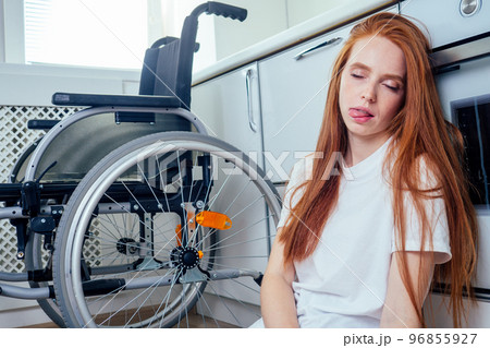 redhaired ginger woman falling down and crawling for help in kitchen room ,holding pills in hands redhaired ginger woman falling down and crawling for help in kitchen room ,holding pills in hands 96855927