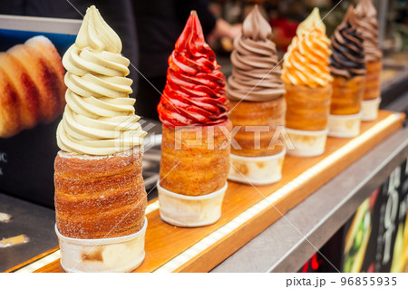 woman with an appetite eats a traditional Czech sweet Trdelnik in Prague street 96855935