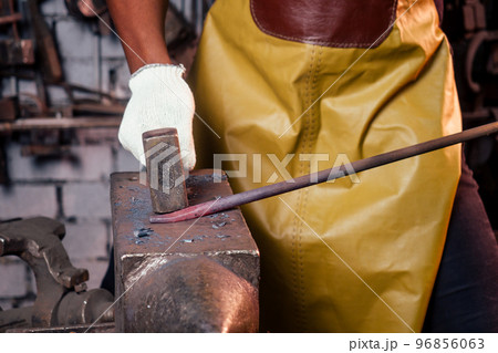 handsome african american blacksmith male worker working in workshop,wearing leather apron 96856063