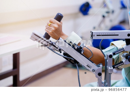 woman wear machine arm for physical therapy. By defining how a robot driven moving technique can be improved to achieve better results in physical rehabilitation 96856477