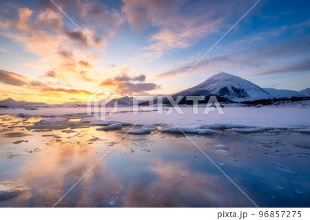 North, Norway. Winter landscape during sunset. Bright sky. Ice and snow on the shore. North, Norway. Winter landscape during sunset. Bright sky. Ice and snow on the shore. 96857275