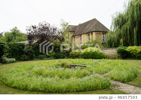 きれいに整備された円形の花壇と薄茶色のレンガ造りの建物　オックスフォードの街並み 96857503