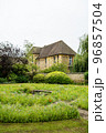 きれいに整備された円形の花壇と薄茶色のレンガ造りの建物　オックスフォードの街並み 96857504