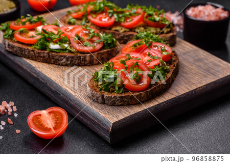 Tasty bruschetta with tomatoes, mozzarella, basil, spices and herbs 96858875