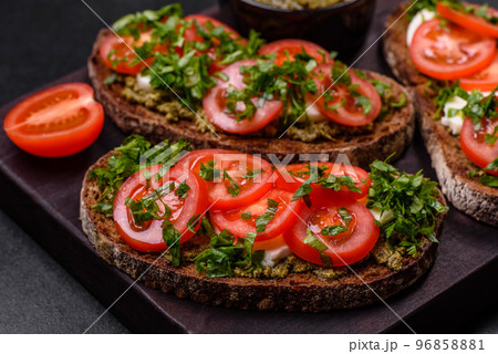 Tasty bruschetta with tomatoes, mozzarella, basil, spices and herbs Tasty bruschetta with tomatoes, mozzarella, basil, spices and herbs 96858881