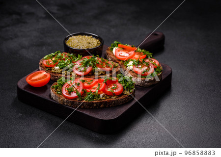 Tasty bruschetta with tomatoes, mozzarella, basil, spices and herbs Tasty bruschetta with tomatoes, mozzarella, basil, spices and herbs 96858883
