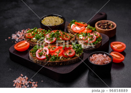 Tasty bruschetta with tomatoes, mozzarella, basil, spices and herbs Tasty bruschetta with tomatoes, mozzarella, basil, spices and herbs 96858889