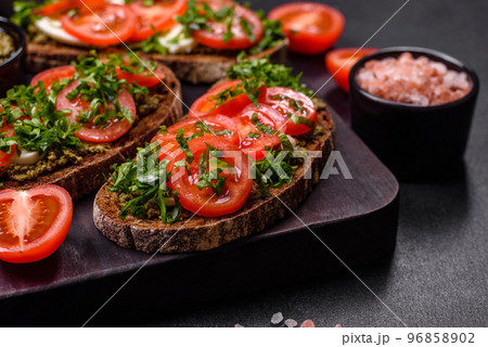 Tasty bruschetta with tomatoes, mozzarella, basil, spices and herbs 96858902