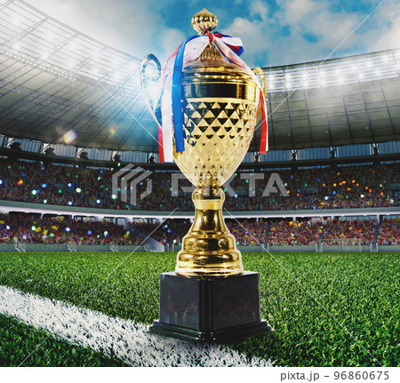 Golden soccer trophy in a football stadium 96860675