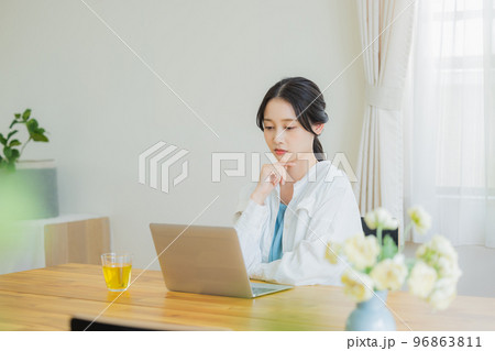 リビングでパソコンを見る女性 96863811