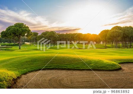Panorama with a sand bunker on a golf course without people with a row of trees in the background during sunset Belek Turkey Panorama with a sand bunker on a golf course without people with a row of trees in the background during sunset Belek Turkey 96863892