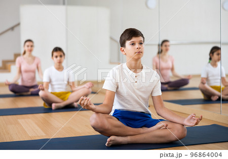 Boy practicing yoga at studio with family Boy practicing yoga at studio with family 96864004