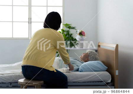 高齢者を看病する女性　介護疲れ 96864844