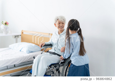 車椅子に乗った高齢者をお見舞いする女の子 車椅子に乗った高齢者をお見舞いする女の子 96864862