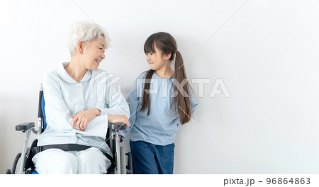 車椅子に乗った高齢者をお見舞いする女の子 96864863