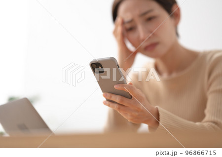 スマートフォン 悩む 女性 スマートフォン 悩む 女性 96866715