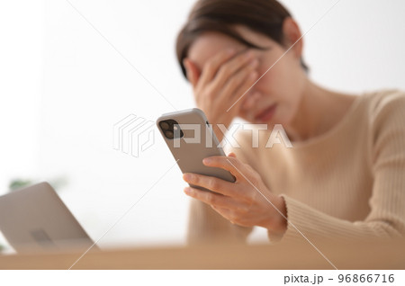 スマートフォン 悩む 女性 スマートフォン 悩む 女性 96866716