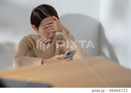 スマートフォン 悩む 女性 スマートフォン 悩む 女性 96866723