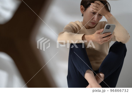 スマートフォン　悩む　女性 96866732