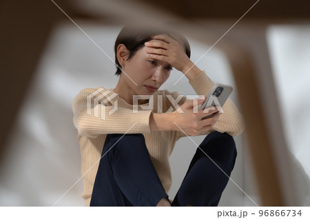 スマートフォン　悩む　女性 96866734