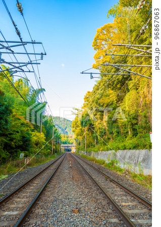 青空と色づく紅葉の森を走る線路｜鉄道イメージ 96867063