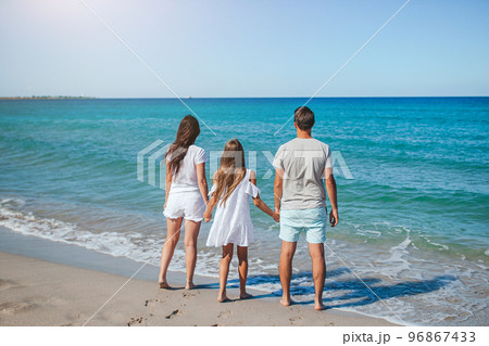Happy family of three on the beach during summer vacation Happy family of three on the beach during summer vacation 96867433