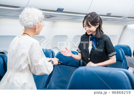 高齢の乗客を案内するキャビンアテンダント 96868259