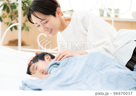 寝起きか寝かしつけるお母さんと子供  96870037
