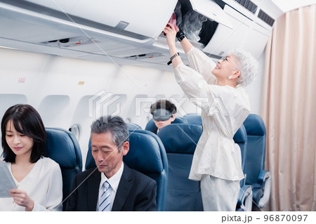 機内持ち込みの荷物を取り出す乗客 96870097