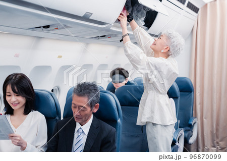 機内持ち込みの荷物を取り出す乗客 96870099