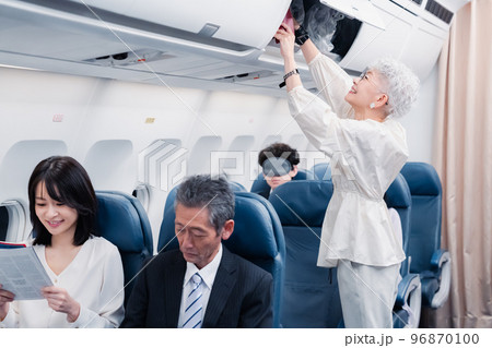 機内持ち込みの荷物を取り出す乗客 96870100