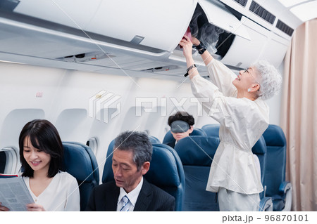 機内持ち込みの荷物を取り出す乗客 96870101