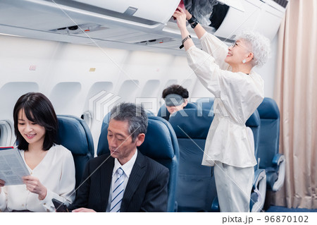 機内持ち込みの荷物を取り出す乗客 96870102