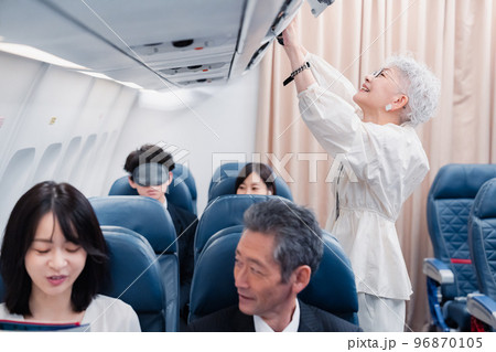 機内持ち込みの荷物を取り出す乗客 機内持ち込みの荷物を取り出す乗客 96870105
