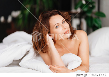 sexy naked brunette woman lying in bed. women's health and attractiveness. sexy naked brunette woman lying in bed. women's health and attractiveness. 96871335